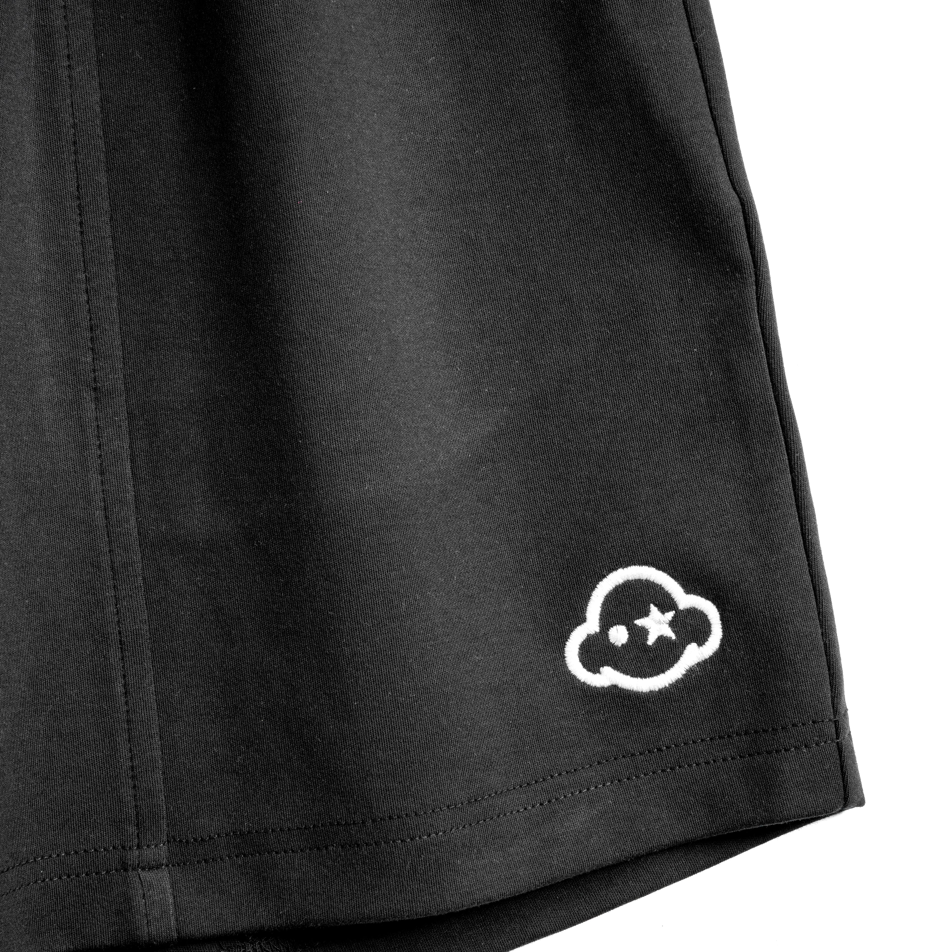 Pitch black cotton loungewear shorts with a relaxed fit, mid-rise, elastic waist, and drawstring. They feature a 3D effect logo embroidered on the left leg and the brand name on the right. White cotton activewear pants with a small black logo on the left leg, featuring a relaxed fit and drawstring waist. 100% Cotton available in Dubai same day delivery best of summer and winter casual streetwear unisex men and women shorts and t-shirts available in UAE fast delivery and same day delivery available Pants jo