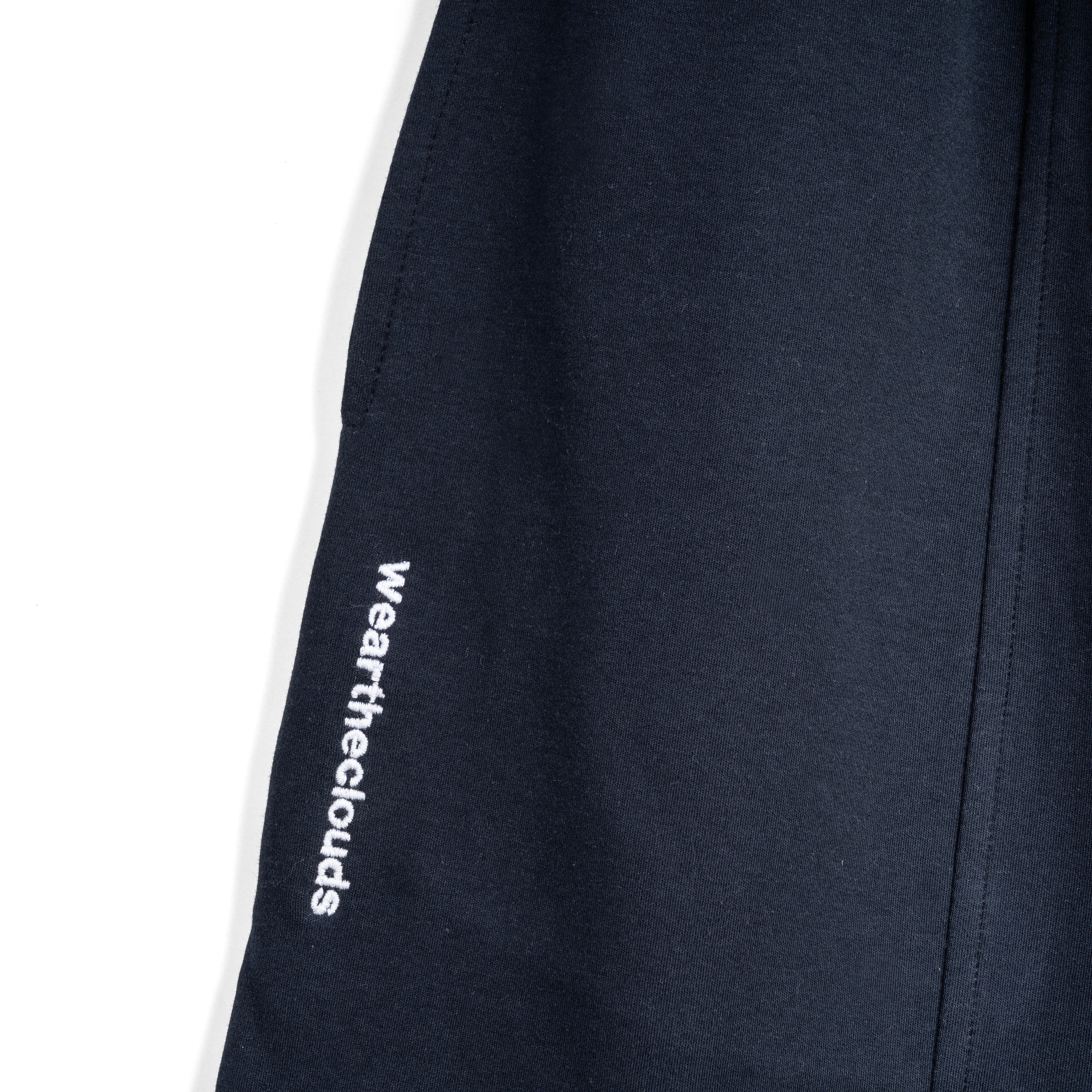 White cotton activewear pants with a small black logo on the left leg, featuring a relaxed fit and drawstring waist. 100% Cotton available in Dubai same day delivery best of summer and winter casual streetwear unisex men and women shorts and t-shirts available in UAE fast delivery and same day delivery available Pants joggers jogger pants