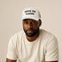 Above The Clouds white trucker cap worn by model – front view