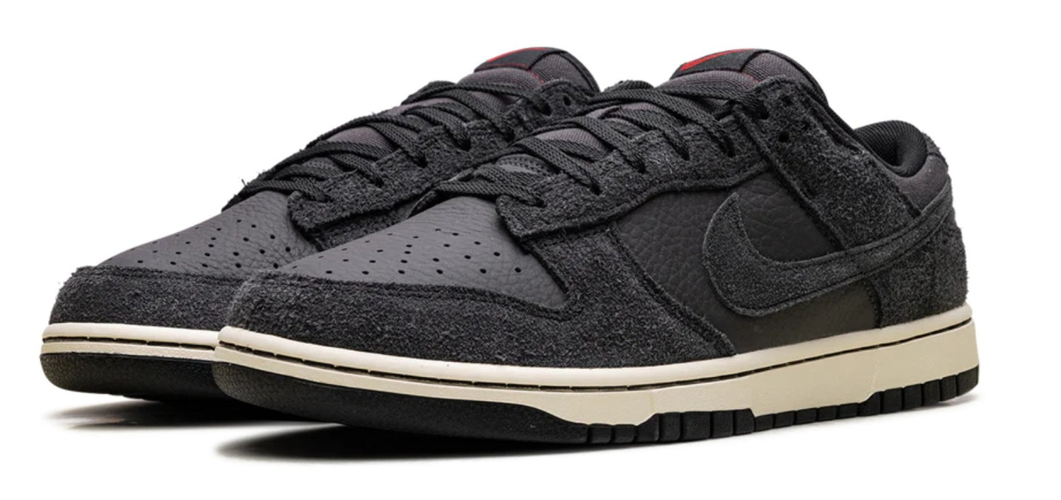 Black Nike sneakers with a white sole on a white background