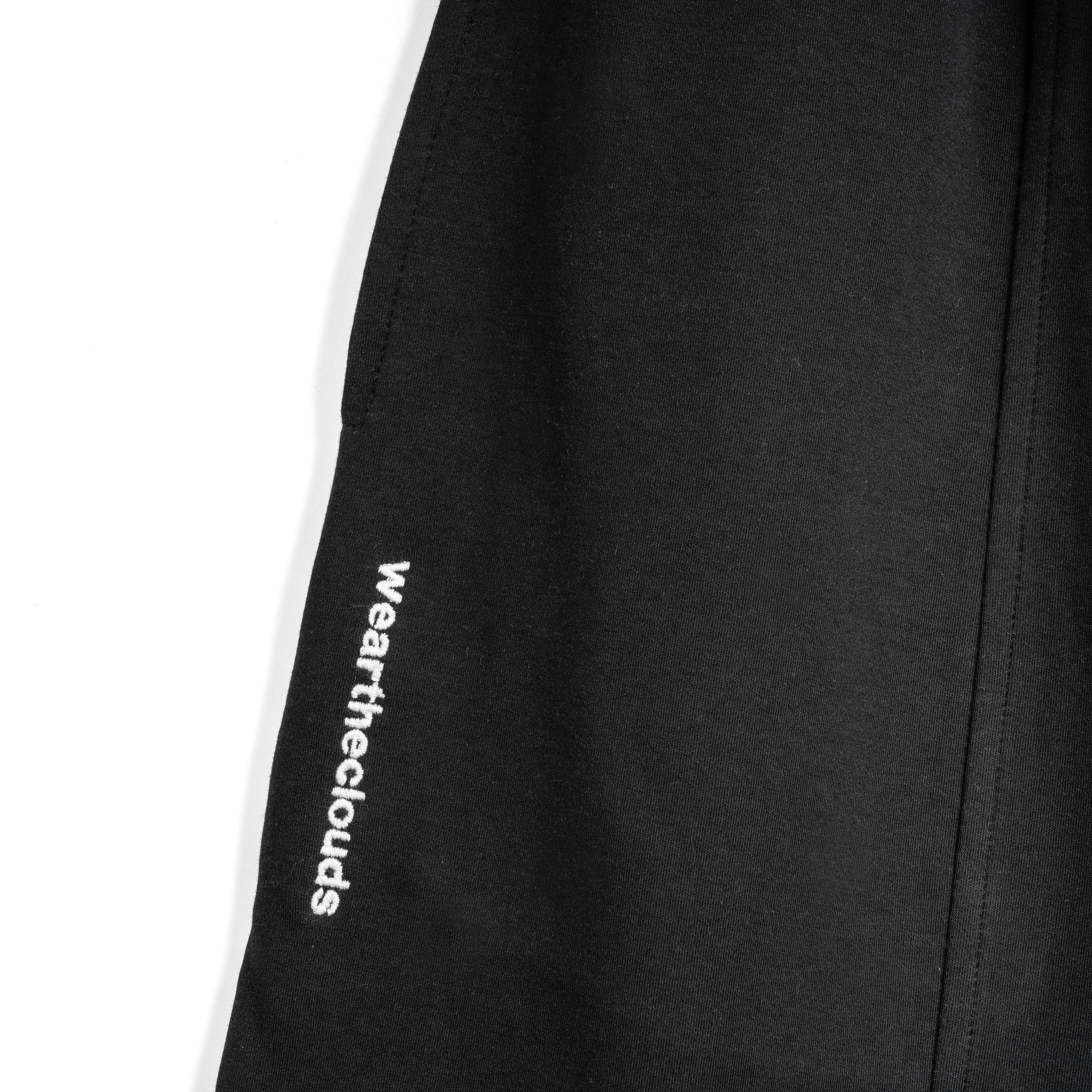 White cotton activewear pants with a small black logo on the left leg, featuring a relaxed fit and drawstring waist. 100% Cotton available in Dubai same day delivery best of summer and winter casual streetwear unisex men and women shorts and t-shirts available in UAE fast delivery and same day delivery available Pants joggers jogger pants