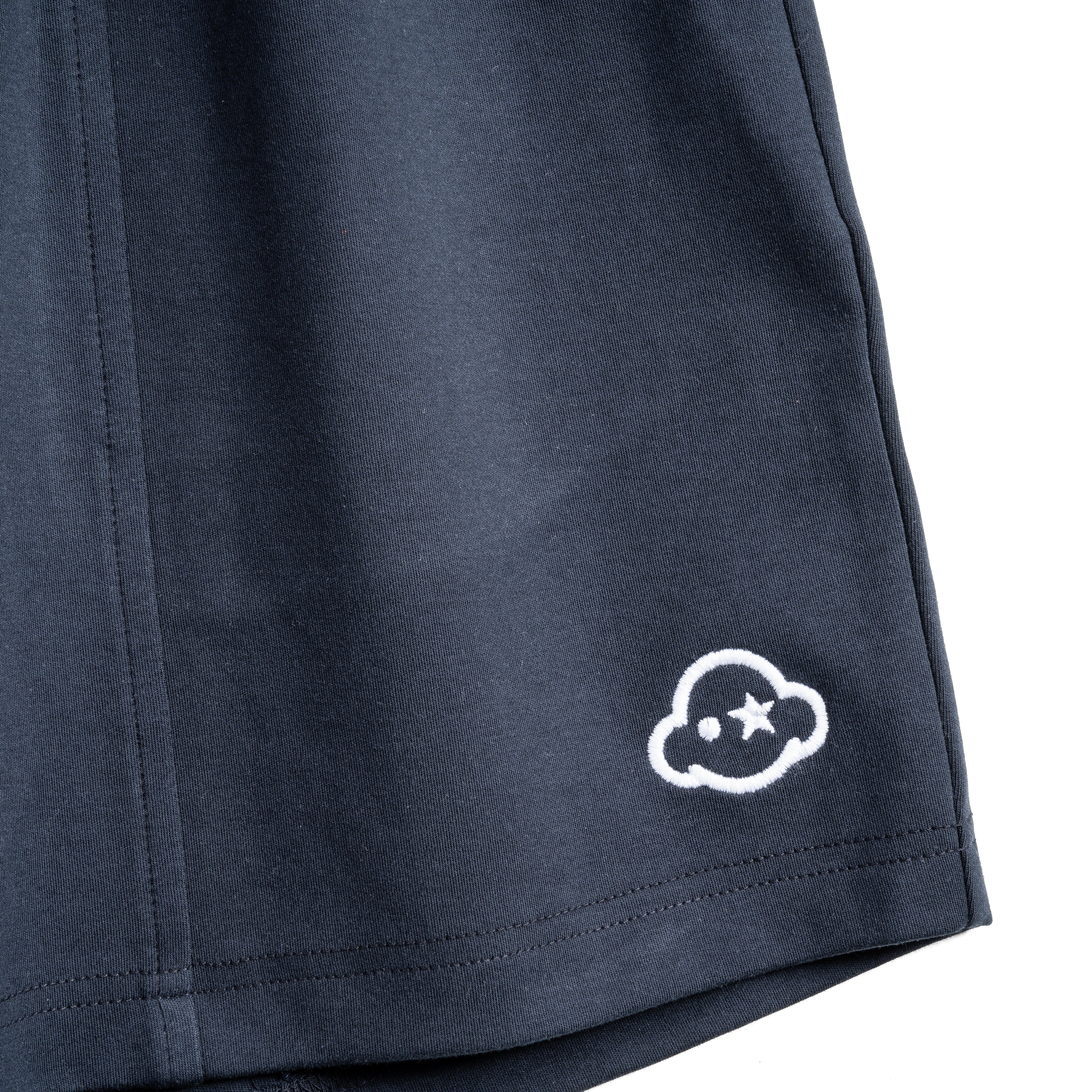 Navy blue cotton loungewear shorts with a relaxed fit, mid-rise, elastic waist, and drawstring. They feature a 3D effect logo embroidered on the left leg and the brand on the right. White cotton activewear pants with a small black logo on the left leg, featuring a relaxed fit and drawstring waist. 100% Cotton available in Dubai same day delivery best of summer and winter casual streetwear unisex men and women shorts and t-shirts available in UAE fast delivery and same day delivery available Pants joggers.