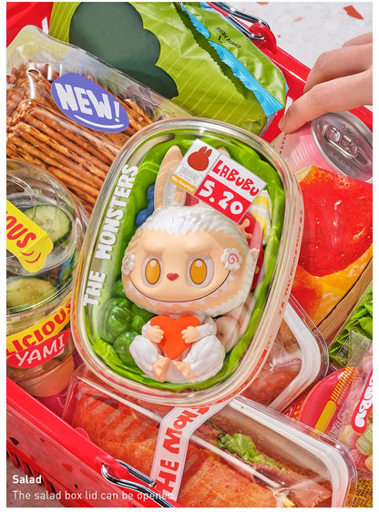 Salad box with a character toy on top, surrounded by snacks and drinks.  Collectible Labubu pop mart toys