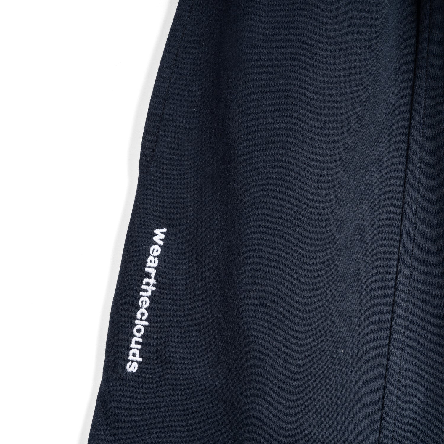 White cotton activewear pants with a small black logo on the left leg, featuring a relaxed fit and drawstring waist. 100% Cotton available in Dubai same day delivery best of summer and winter casual streetwear unisex men and women shorts and t-shirts available in UAE fast delivery and same day delivery available Pants joggers jogger pants