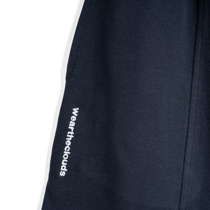 White cotton activewear pants with a small black logo on the left leg, featuring a relaxed fit and drawstring waist. 100% Cotton available in Dubai same day delivery best of summer and winter casual streetwear unisex men and women shorts and t-shirts available in UAE fast delivery and same day delivery available Pants joggers jogger pants